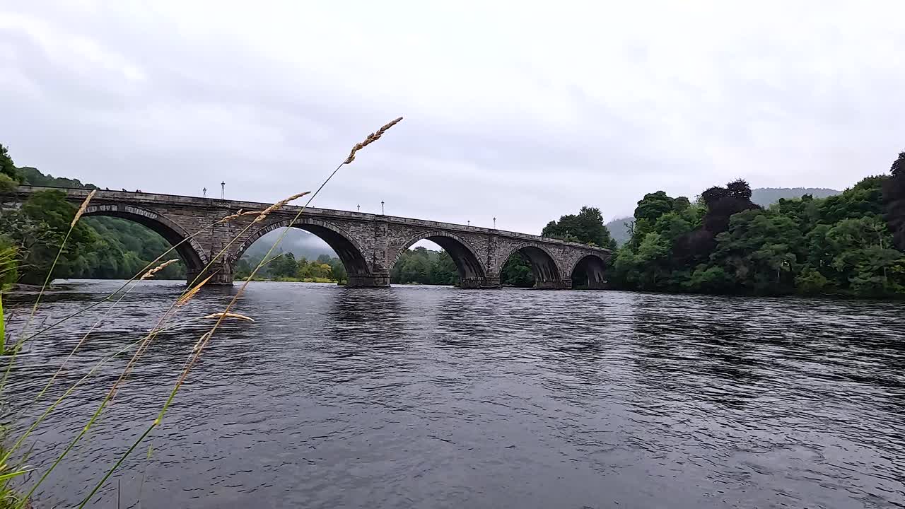 평온한 강이 역사적인 돌 다리 에서 흐른다.