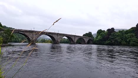 el río tranquilo fluye bajo el histórico puente de piedra.