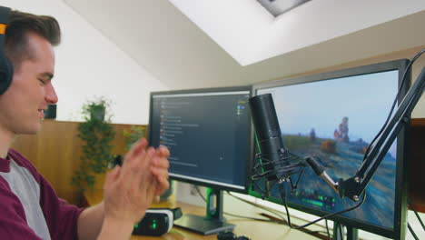 man gaming at home sitting at desk wearing headphones for live stream