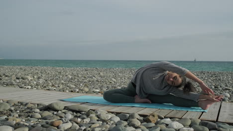 woman practicing yoga on a beach