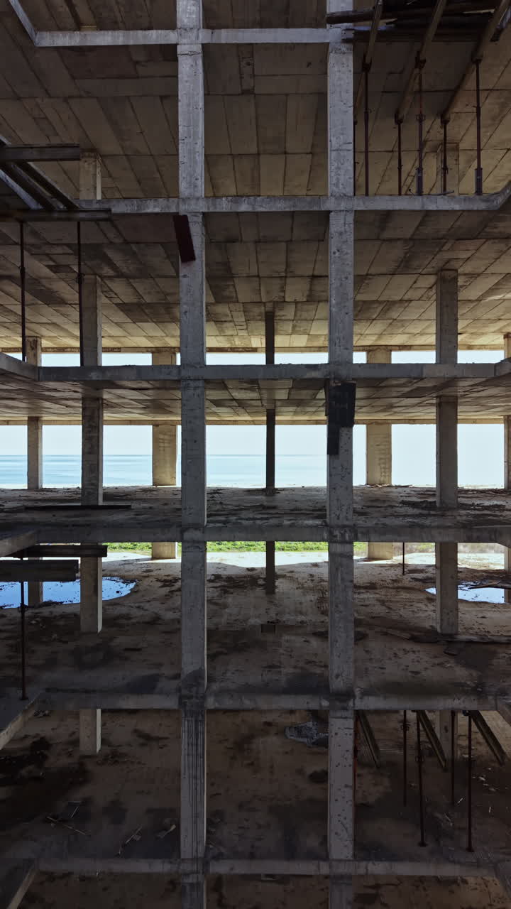 Building skeleton reveals a stunning sea view from within a coastal construction site on a bright, sunny day
