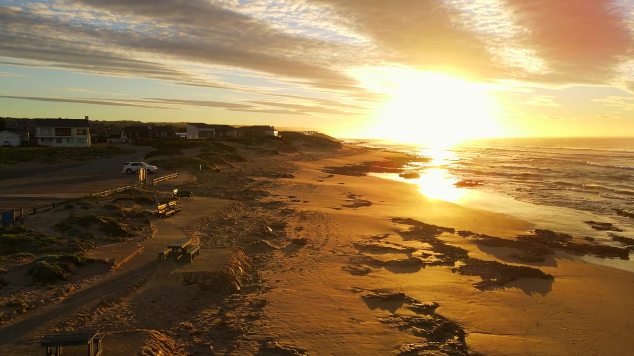 Naturskøn luftdolly-optagelse ved solopgang over stranden ved kystbyen Witsand på Garden Route.