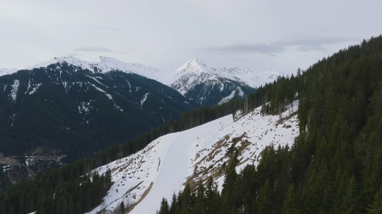 picos cubiertos de nieve en la estación de esquí austriaca de saalbach-hinterglemm, pinos que salpican el paisaje, vista aérea