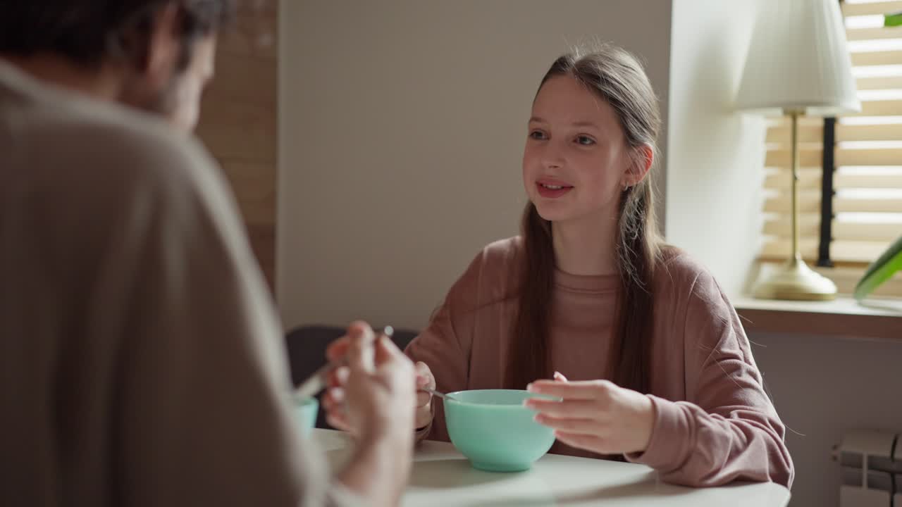 Teenage girl eating breakfast with family