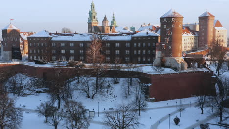 panorama of snow-covered wawel castle and old town at magic morning with soft sun light during winter, krakow, poland