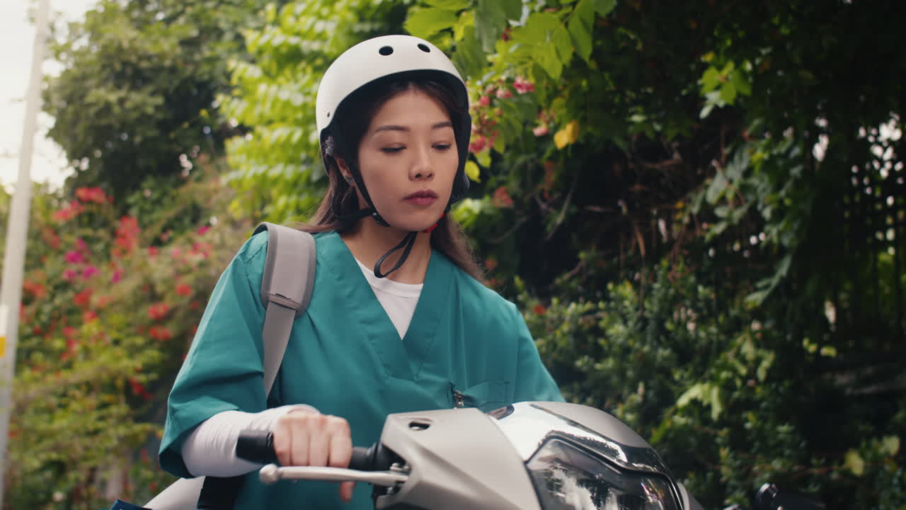 Vertical of Female Doctor Putting on Helmet to Ride Motorcycle