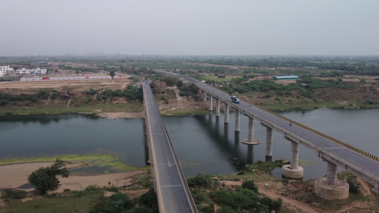 Vista aerea del ponte autostradale sul letto di un fiume in secca nell'India rurale sotto il cielo grigio