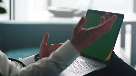 hombre de negocios desconocido trabajando en una computadora portátil con pantalla verde en la oficina