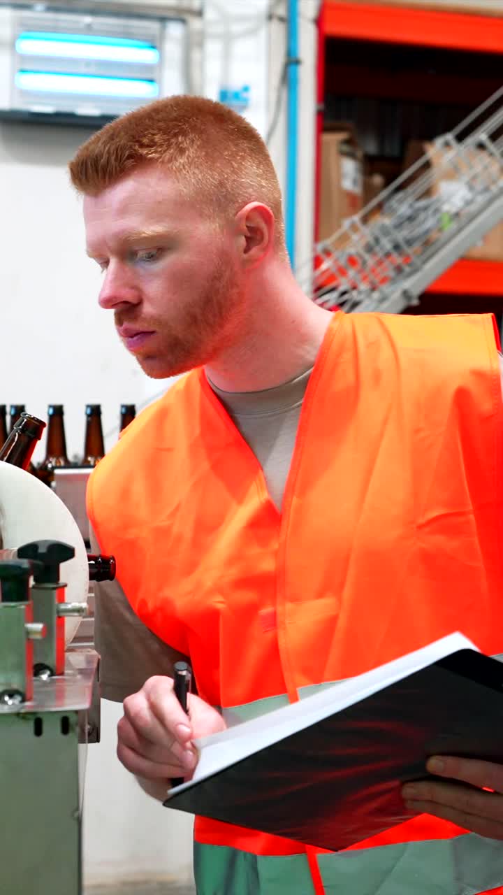 Factory worker inspecting beer bottle production