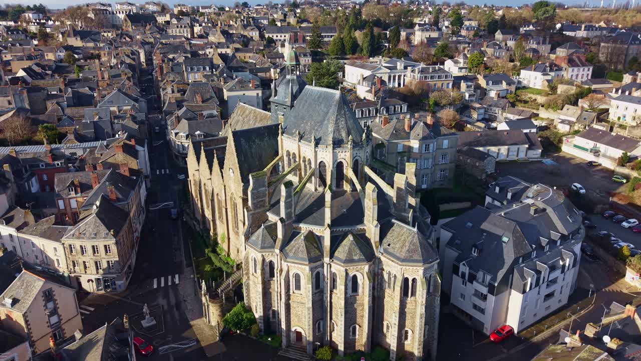Lento movimento di drone in avvicinamento alla basilica gotica di Notre Dame des Miracles che mostra archi rampanti, Mayenne Centre-Ville, Pays de la Loire, Francia