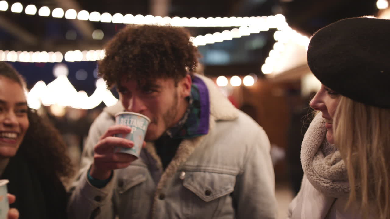 크리스마스 시장 에서 뜨거운 와인 을 마시는 친구 들 의 그룹