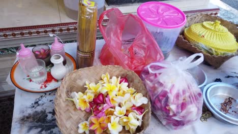 Balinese-Frangipani-Flowers-Yellow,-Pink,-Holy-Water,-Priest-Offerings-Ceremony-Sage-for-Praying-in-Hindu-Religion,-Bali-Indonesia