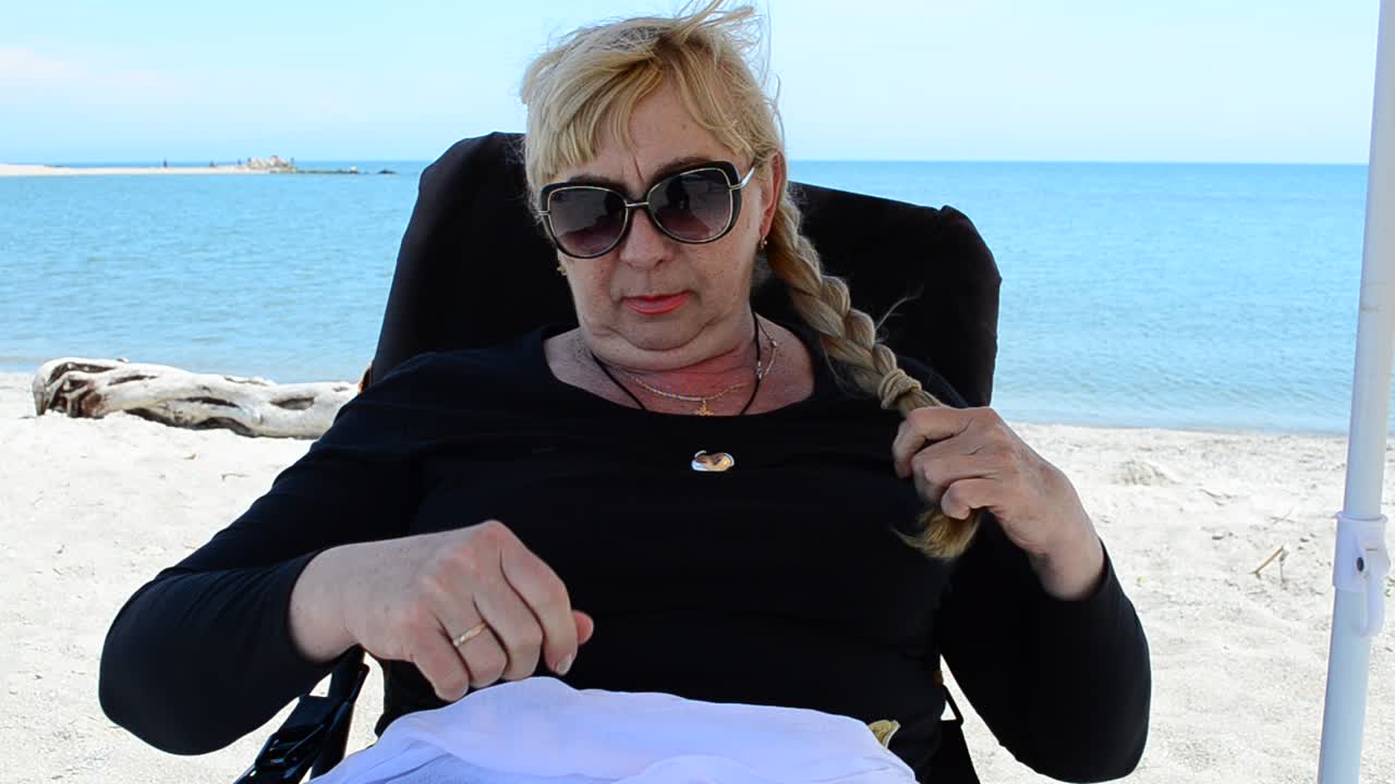 La mujer hace una trenza. Peinado