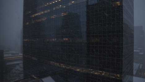 establishing shot of a corporate high rise office building during a blizzard