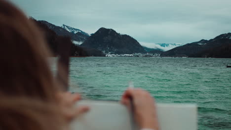 artist painting mountain lake scenery