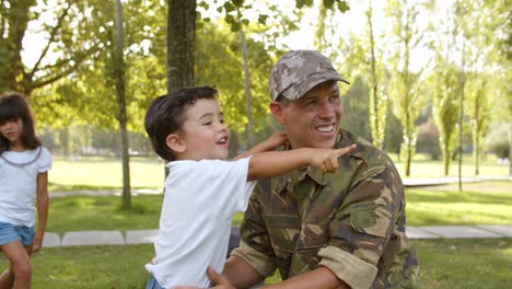 Glücklicher-Militärvater,-Der-Die-Freizeit-Mit-Sohn-Im-Park-Genießt