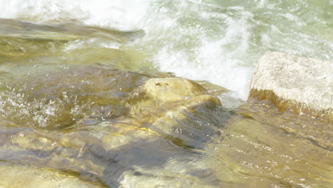 Crystal-clear-drinking-water-flows-between-stones-of-a-river-or-stream