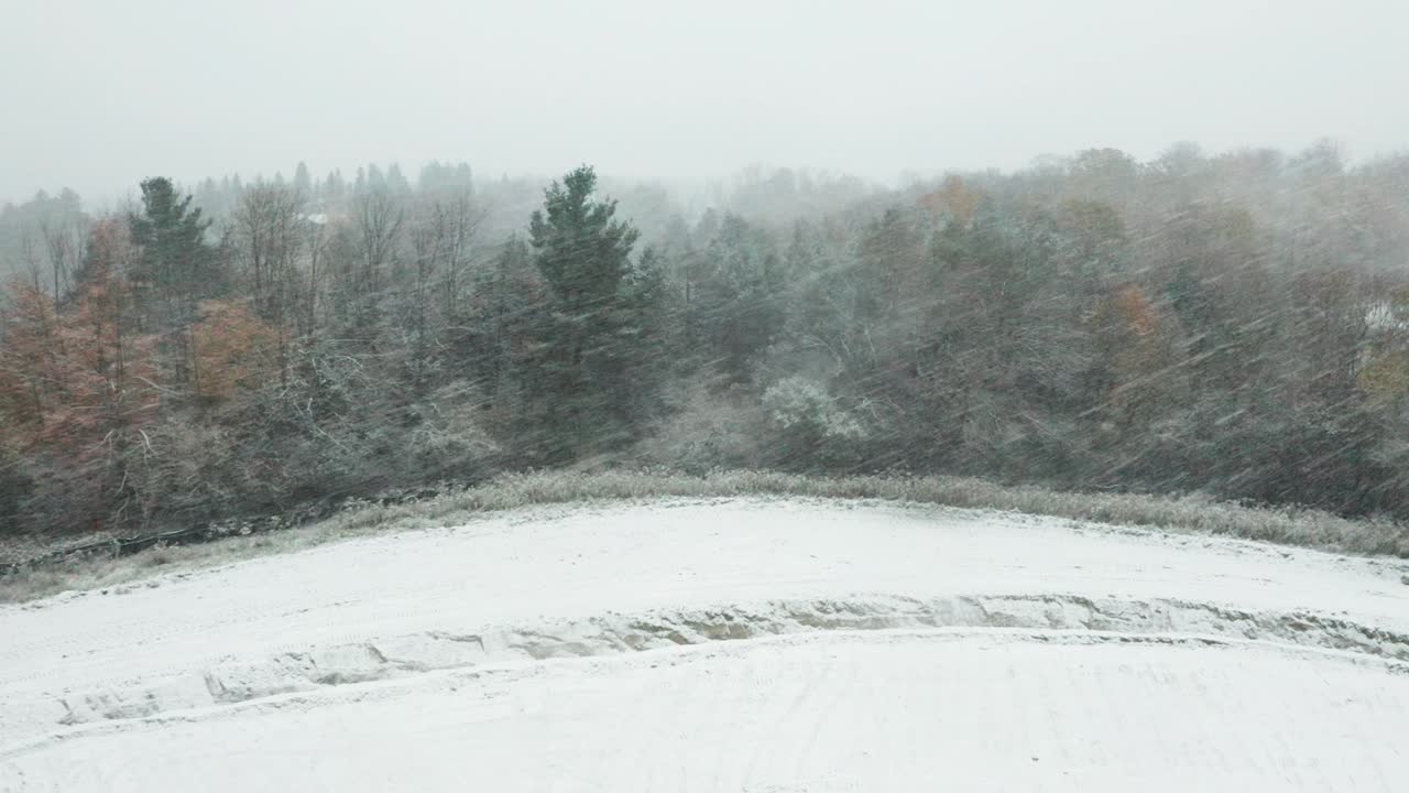 Aerial of a Canadian rural landscape and a strong blizzard coming from the side