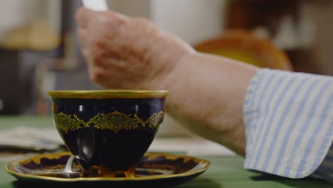 elderly person relaxes with tea cup reading personal mail letter medium shot
