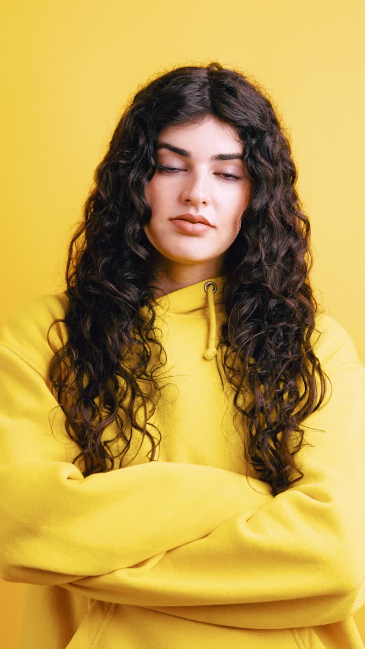 Portrait of a woman with curly hair in a yellow hoodie