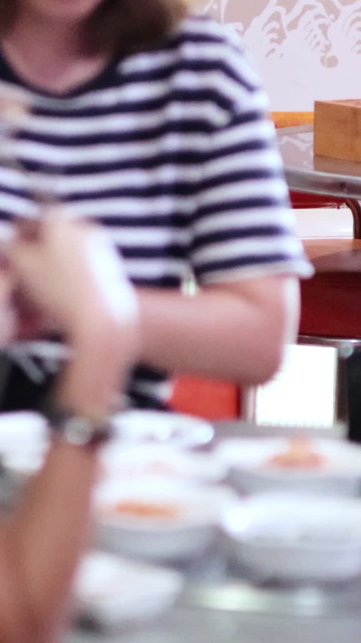 두 명의 여성이 식당에서 먹고 얘기하고 있습니다.