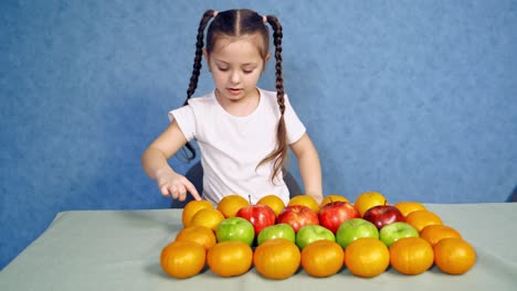 girl with fruit on table. happy cute kid girl with healthy food