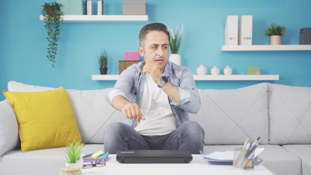 분노한 표정으로 노트북을 닫는 남자.