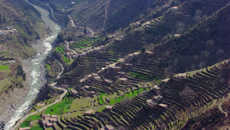 a picturesque village with beautiful scenes of mountains and river aerial view, as well as charmingly crafted greenery with a road where traffic is moving
