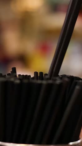 seleccionando a mano las pajitas negras del recipiente