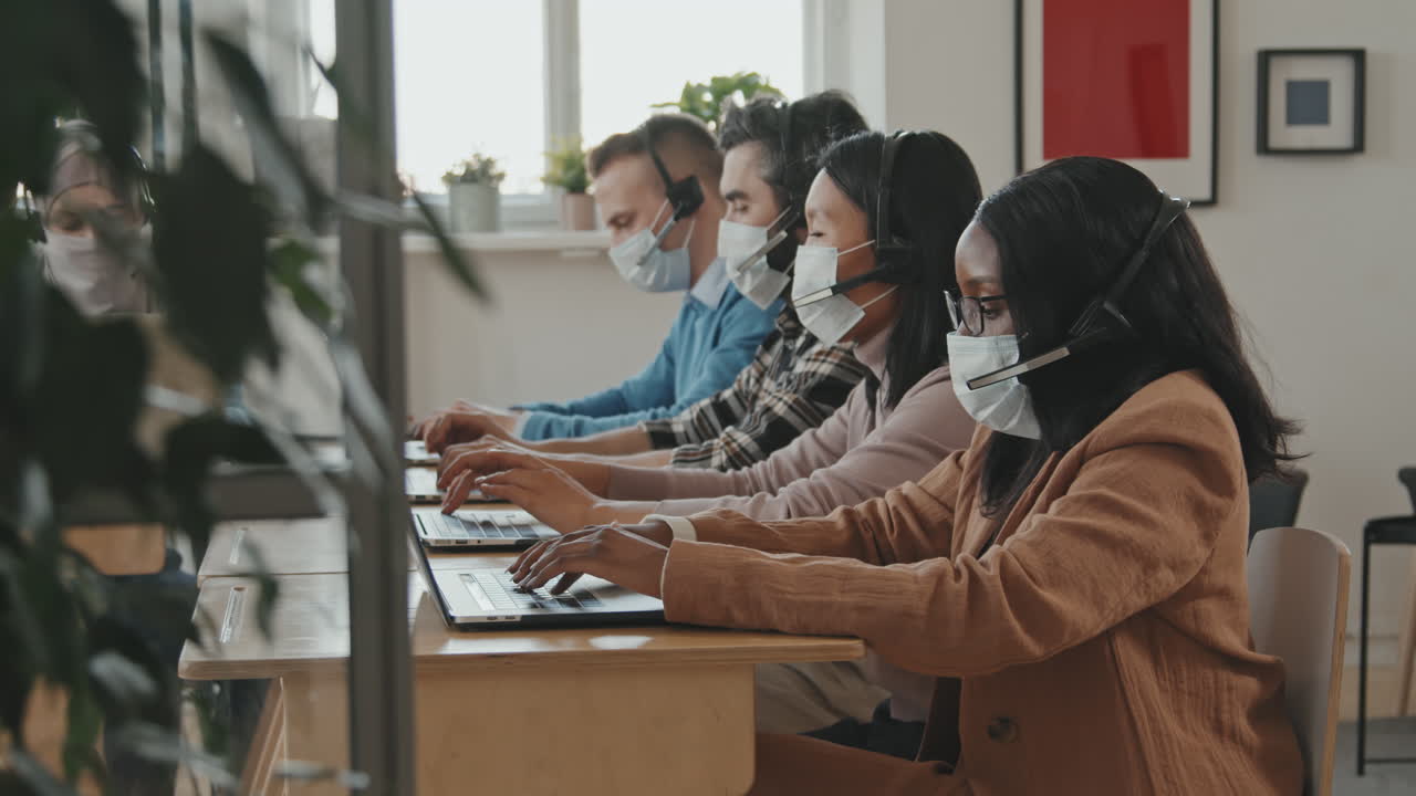 People in Face Masks Working in Call Center