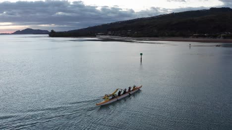 Close-up-aerial-panning-shot-of-an-outrigger-canoe-on-the-ocean-in-O'ahu,-Hawaii