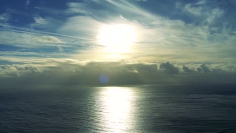 footage of the horizon with the sun above the clouds and the ocean