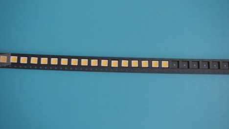 slowly moving black tape with electronics components on blue background