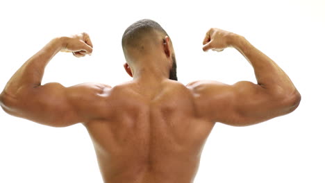 strong fit african american athletic man flexing biceps and back muscles in front of a white background