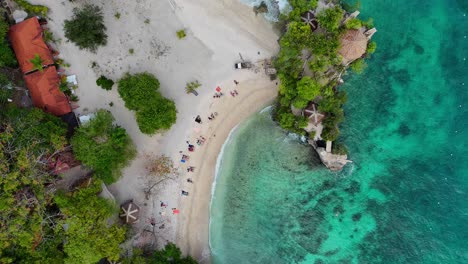 Top-down-drone-footage-of-a-white-beach-with-tourists-and-turquoise-water-on-Siquijor-in-the-Philippines