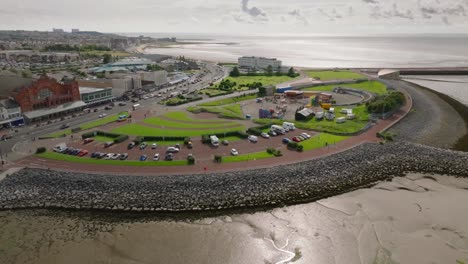 eden project proposed site. semicircular headland with small fairground rides. summer. marine road central, morecambe, lancashire, uk