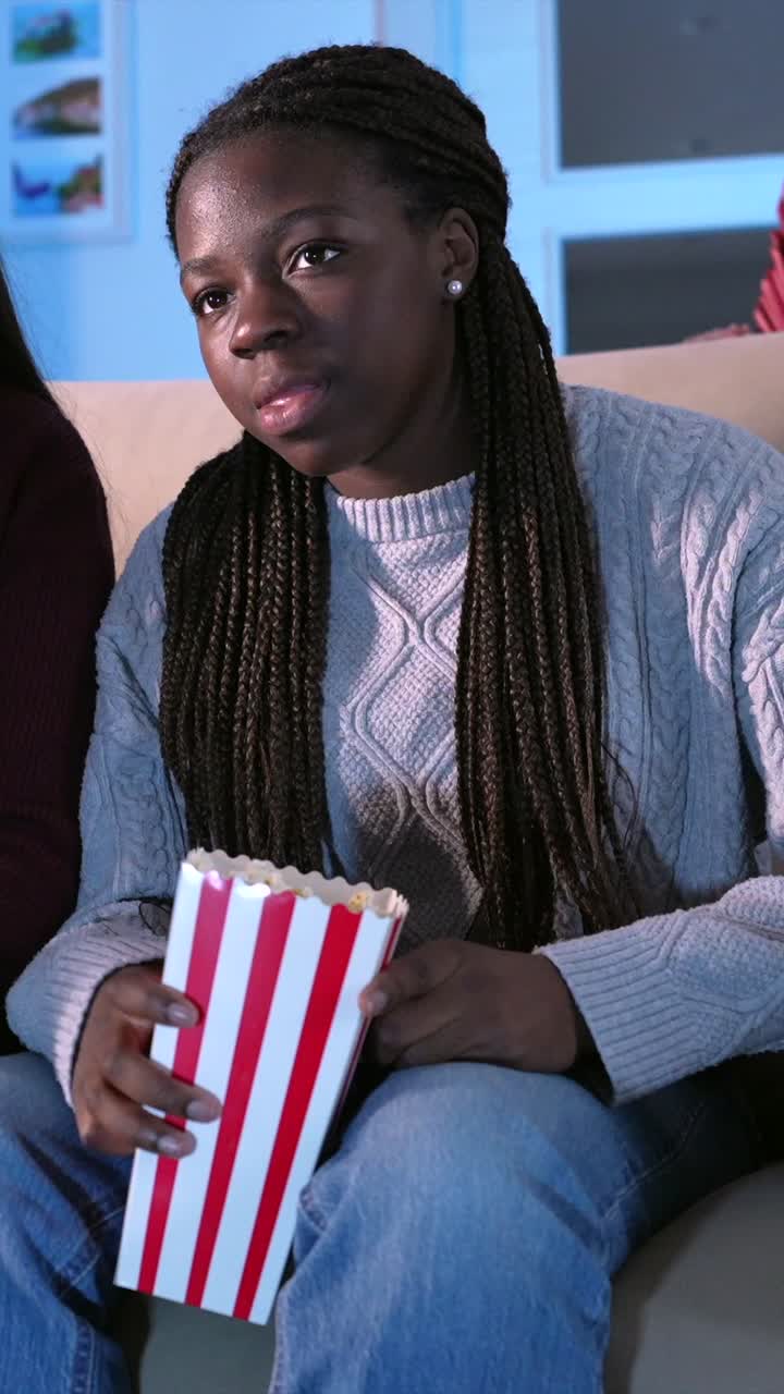 Amici che guardano un film e mangiano popcorn