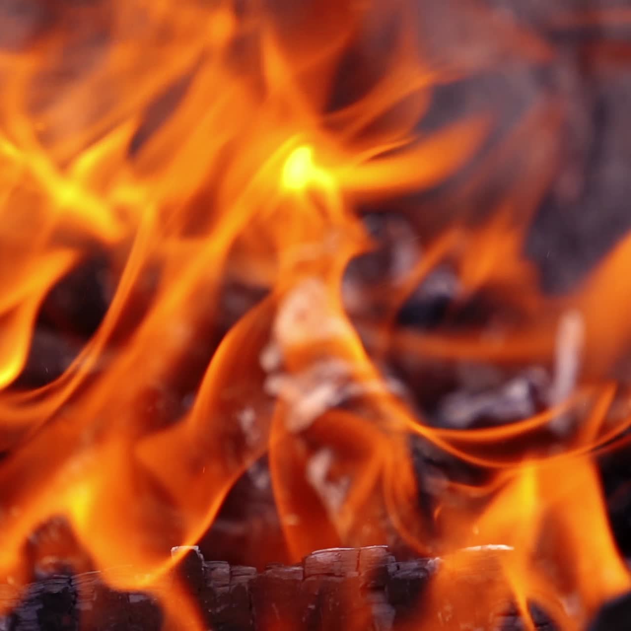 Bright bonfire with beautiful sparks. Charcoals in vivid flame. Combustion of smoldering logs in fire. Slow motion.