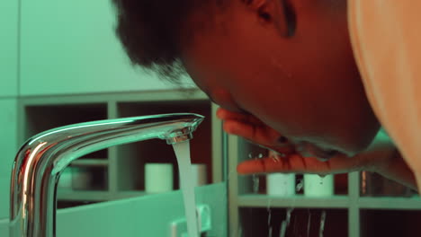 african american woman washing face in bathroom