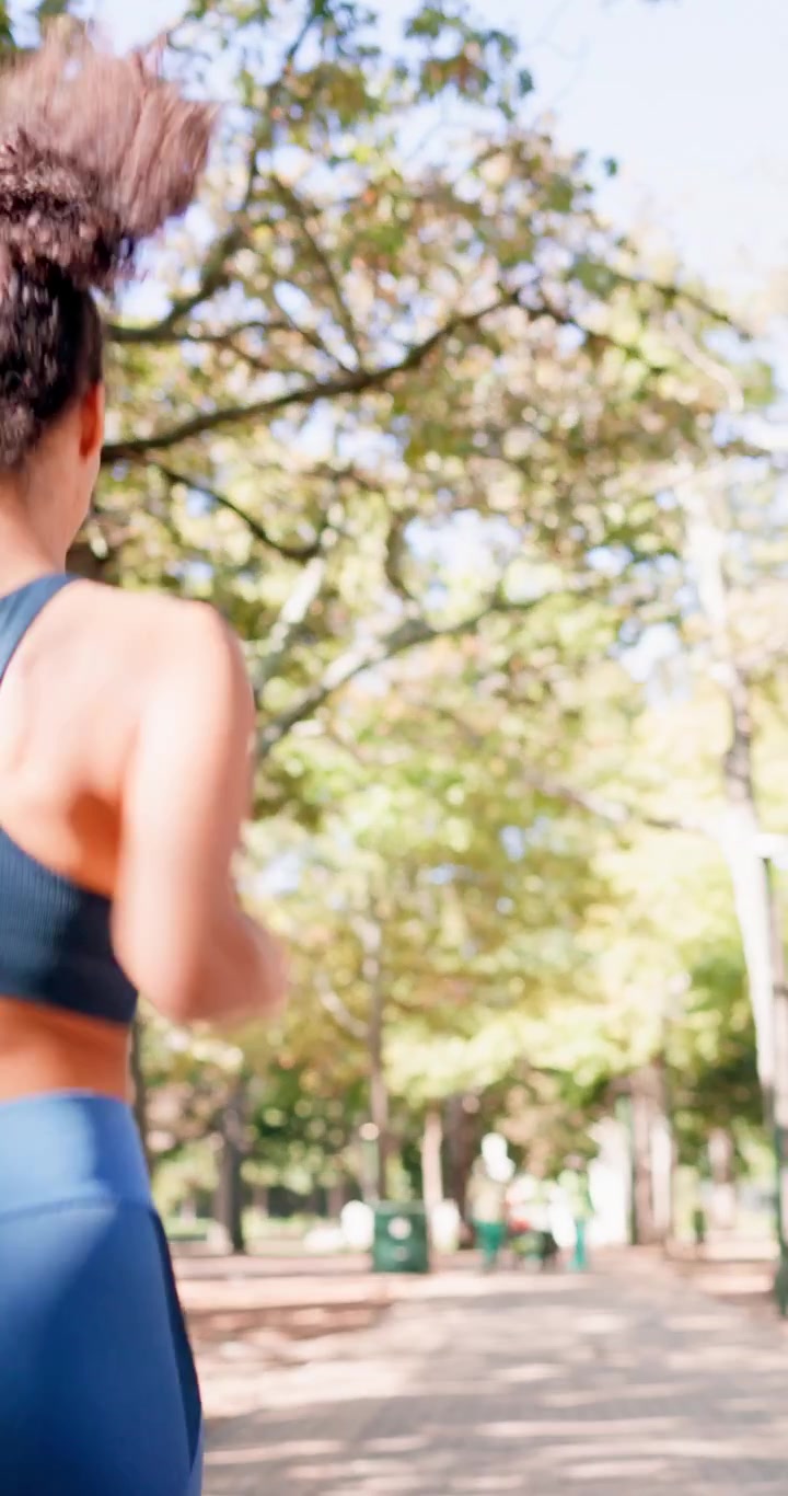 Aktivt par jogger sammen på en solbeskinnet sti i parken