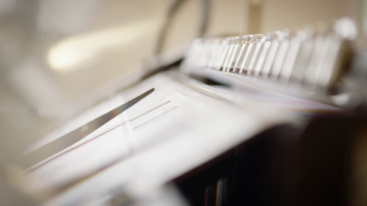Detail of a printing machine, mechanical hand grips a sheet of paper and slides it over on the other side