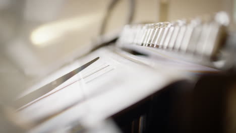 detail of a printing machine, mechanical hand grips a sheet of paper and slides it over on the other side