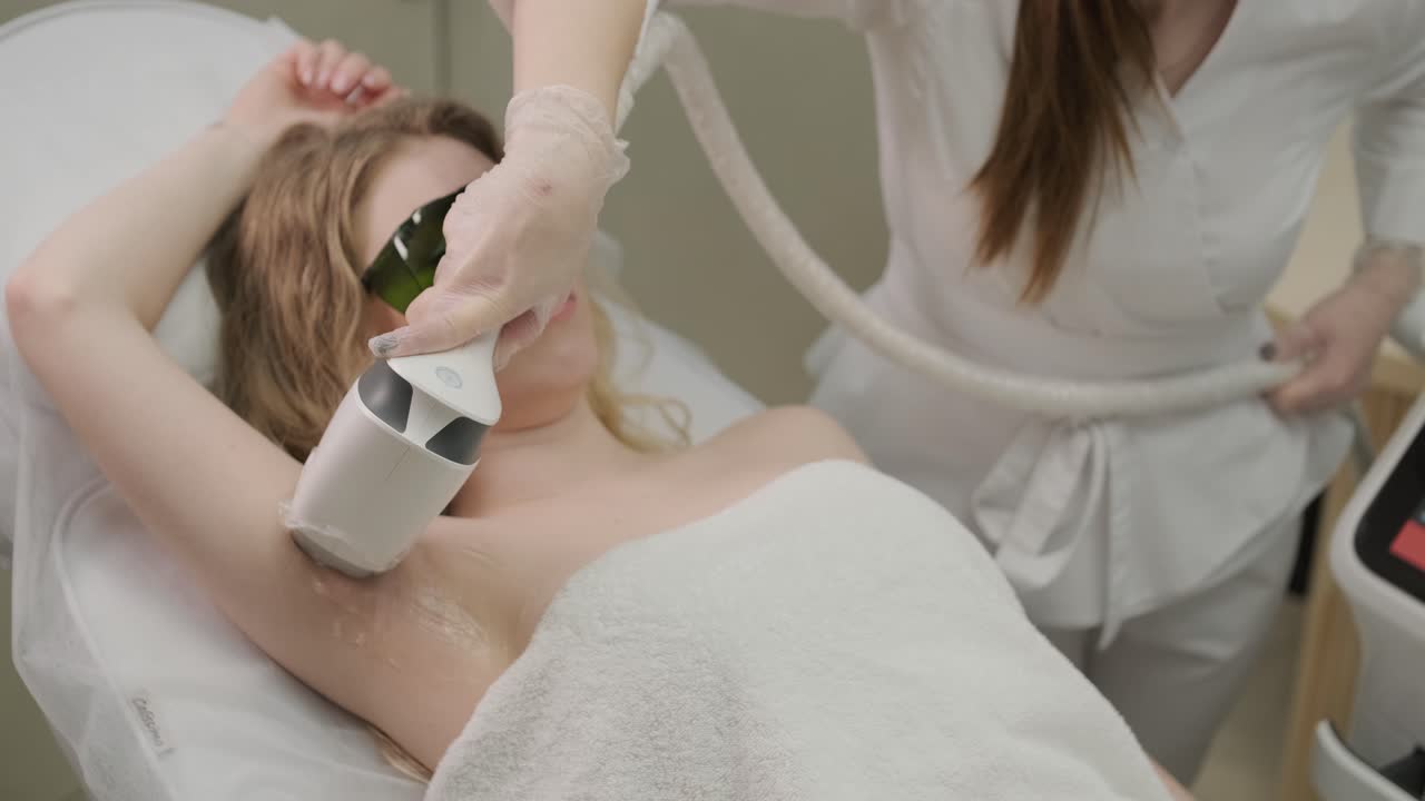 Woman armpit area during procedure of laser hair removal in modern cosmetology clinic. Concept of women beauty, cosmetology, epilation