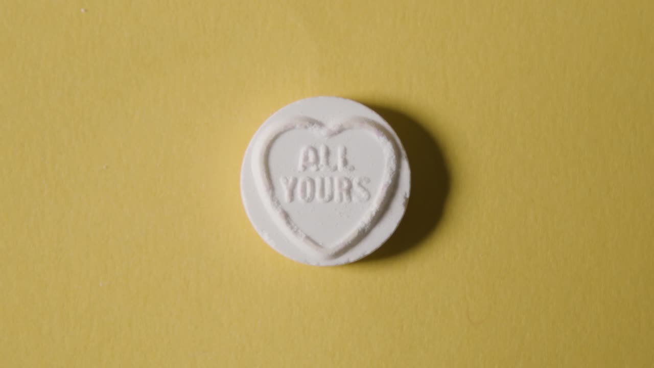 dulces de corazón con todo tu mensaje sobre fondo amarillo