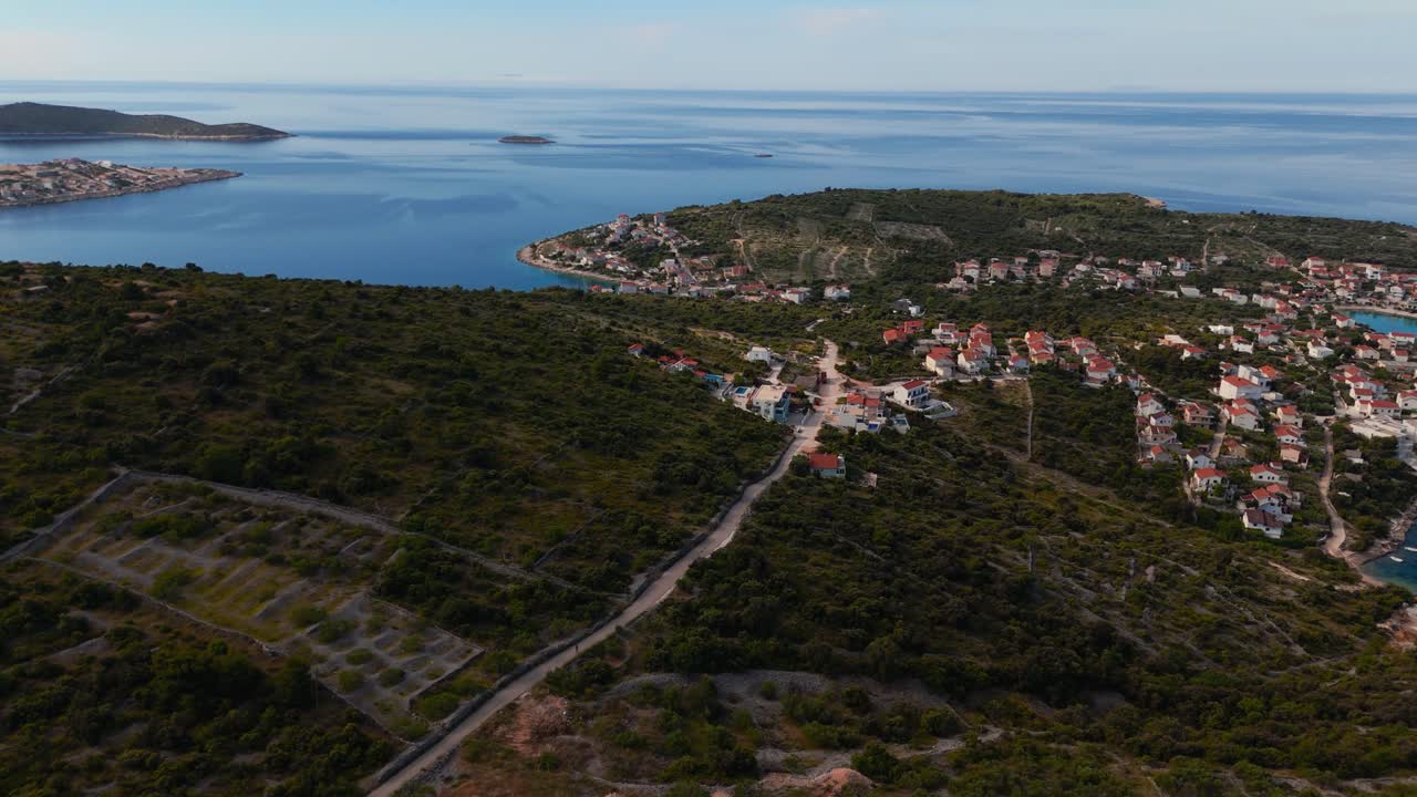 Coastal village of Kanica, Croatia seen from above with clear blue sea, islands and rocky shoreline.