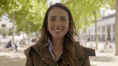 Mujer-Joven-Sonriente-Parada-En-La-Calle-Y-Soplando-Un-Beso-Al-Aire.