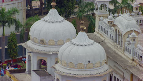 a close up drone view of the minarets of the sikh`s temple, sikh community sat and rest at the park of the temple