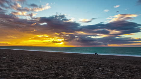 silueta de personas de pie en la costa de la playa desde el atardecer hasta la noche