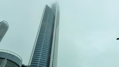 un ciclón se acerca a gold coast, australia, con altos rascacielos y calles vacías bajo cielos nublados y lluvia