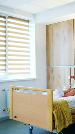 big light comfortable ward in the maternity hospital. pregnant lady lies on the bed under the drop counter. preparation before childbirth. vertical video